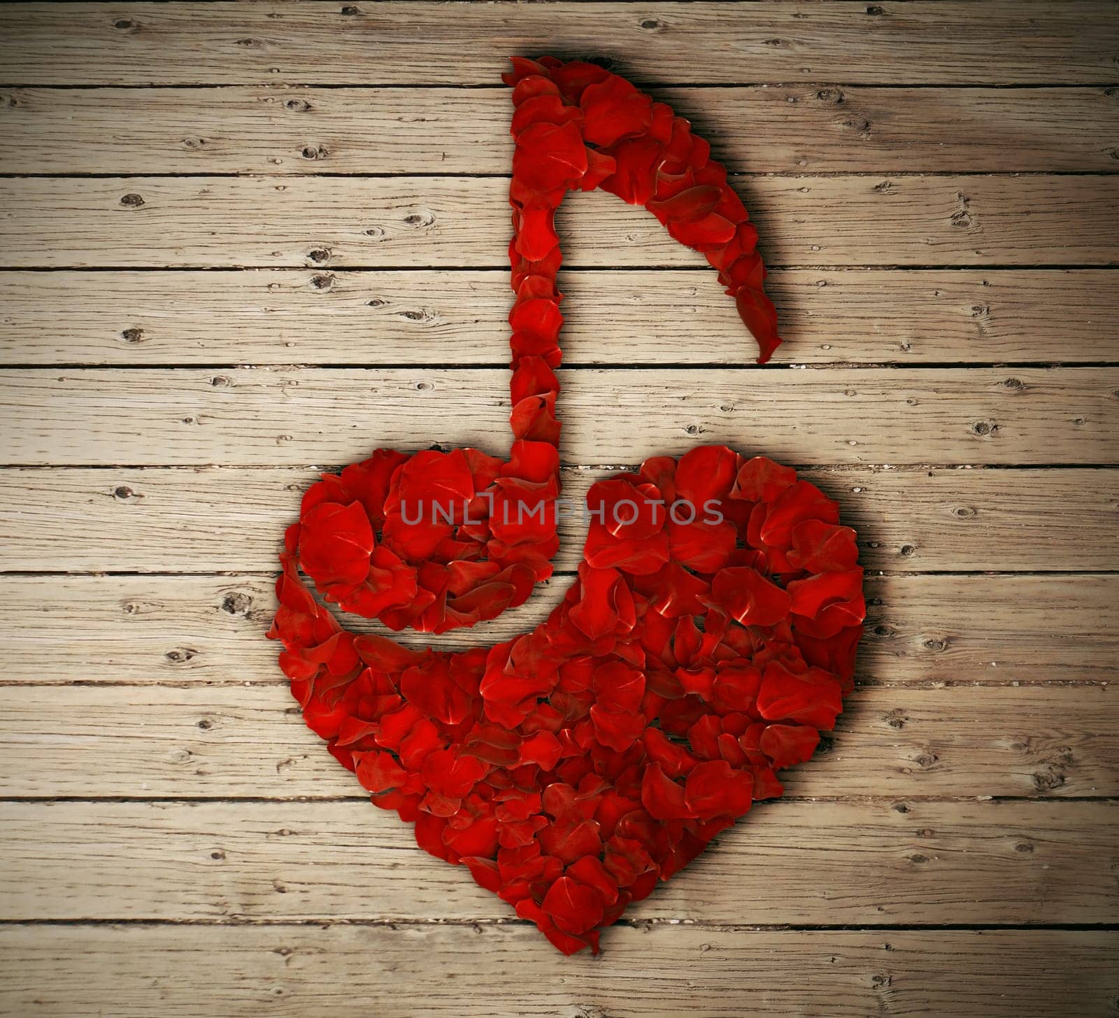 Red rose petals arranged in shape of heart with a music note inside isolated on wooden table. Love music concept