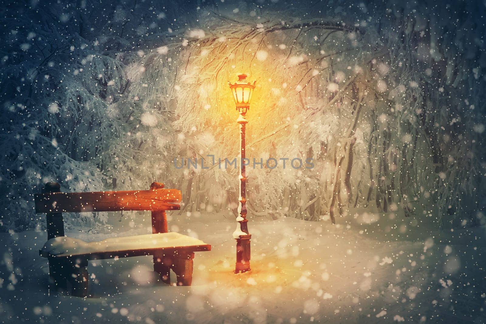 Wintertime night scene in the park. Shining street lamp near a wooden bench covered with snow. Wonderful winter holidays seasonal background. Christmas Eve and New year magic Noel atmosphere