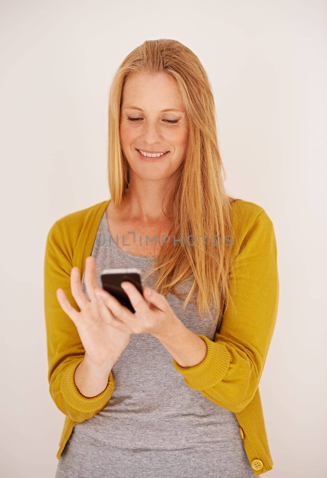 Smile, woman and smartphone for contact, communication and texting with technology isolated on white background. Happy, female person and mobile phone for connectivity, internet and app in studio.