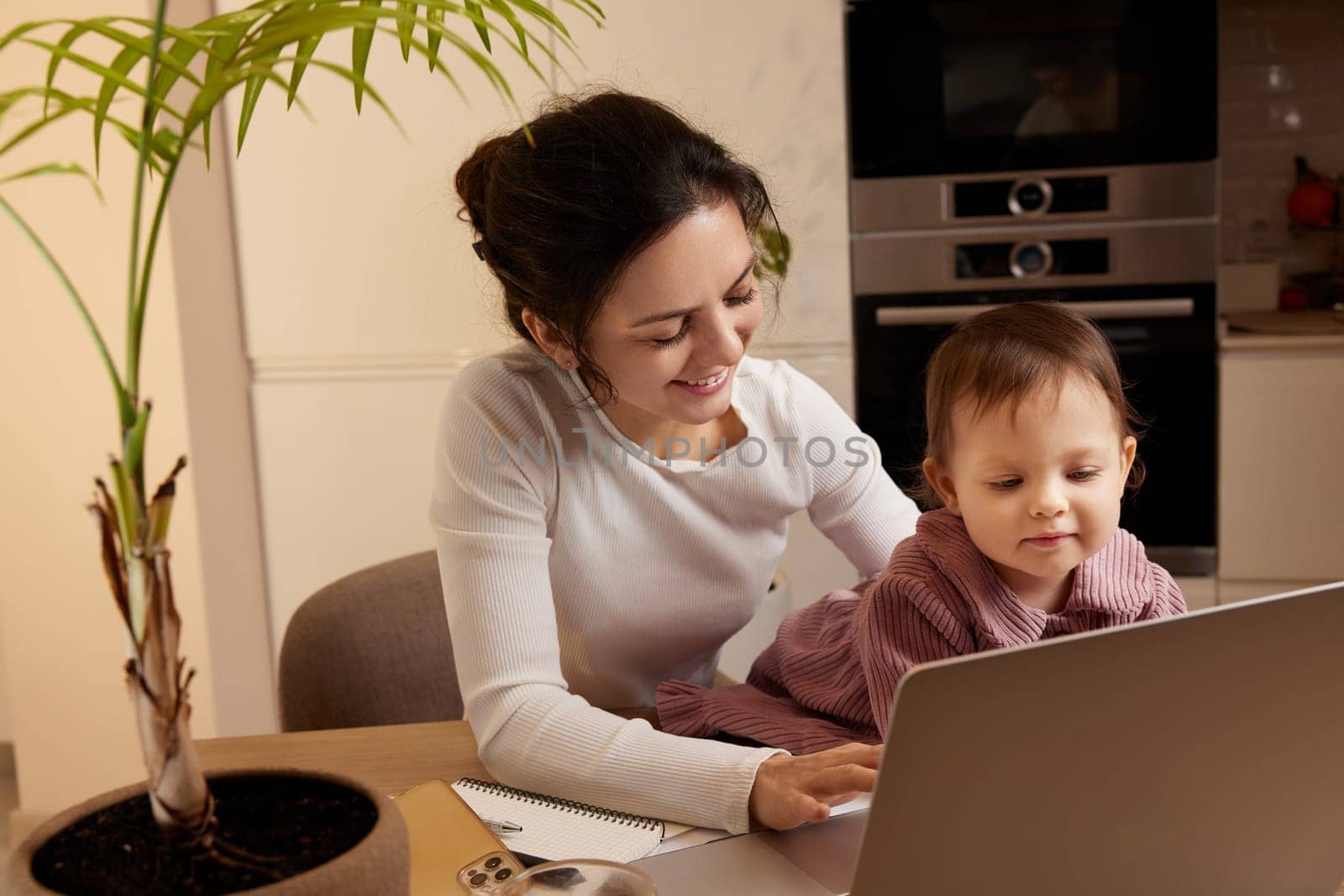 businesswoman working at home with her little child girl by erstudio