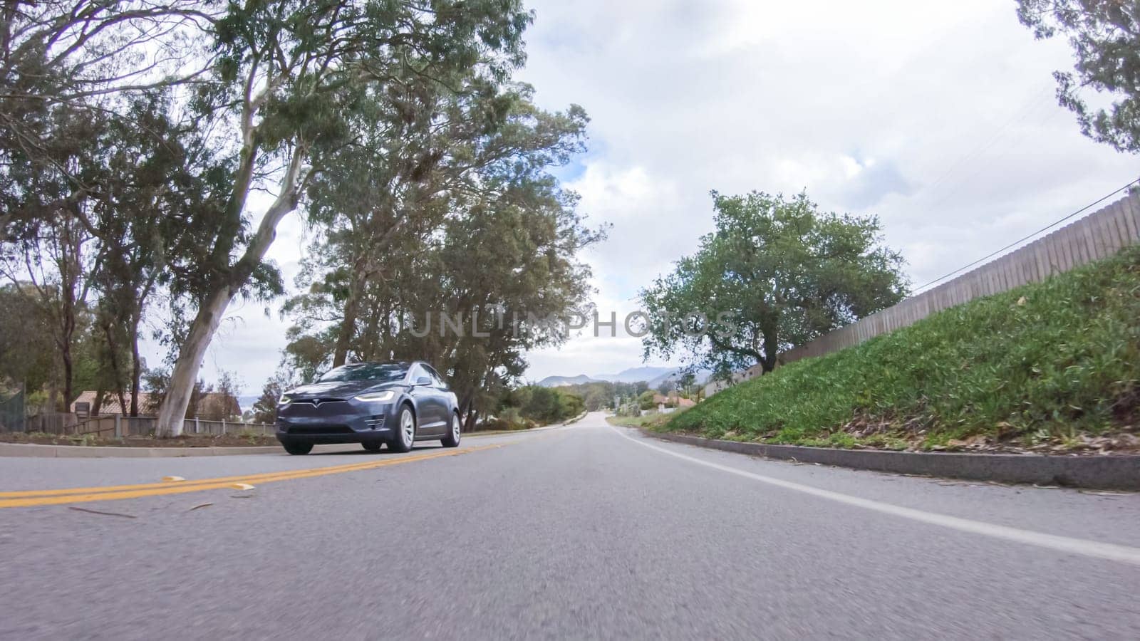 Santa Maria, California, USA-December 6, 2022-Vehicle navigates the streets of Morro Bay, California, during a cloudy winter day. The atmosphere is moody and serene as the overcast sky casts a soft light on the charming buildings and quiet streets of this coastal town.