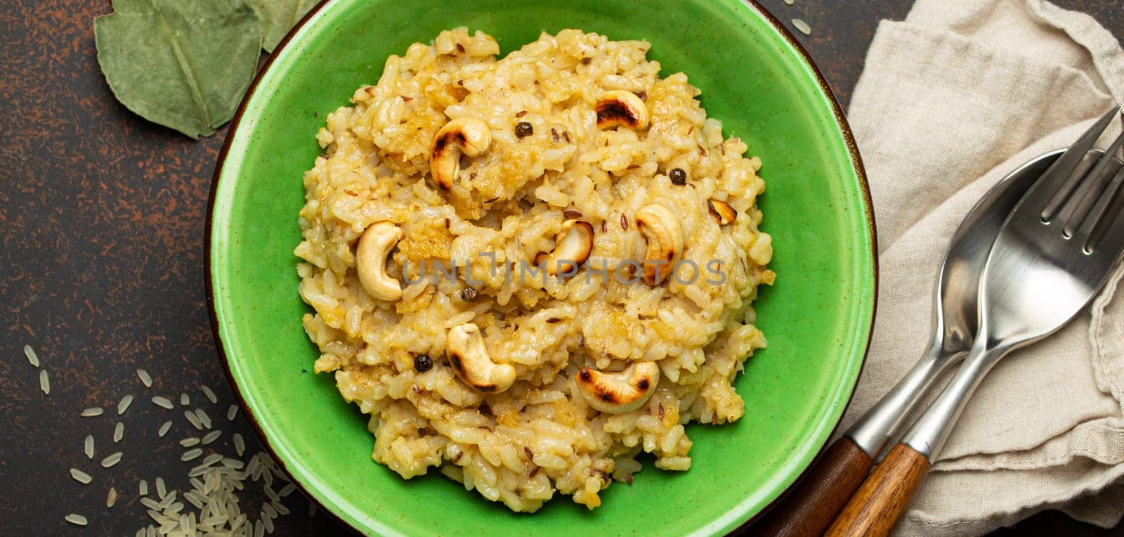 Ven Pongal (Khara Pongal), traditional Indian savoury rice dish made during celebrating Pongal festival, served in bowl top view on concrete rustic background.