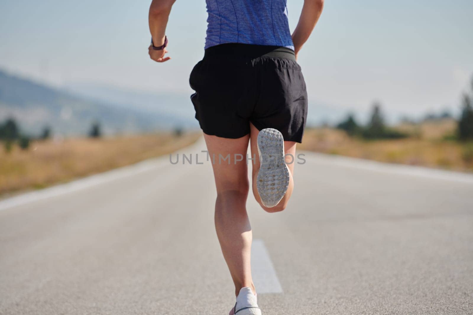 A determined woman athlete trains for success in the morning sun. by dotshock