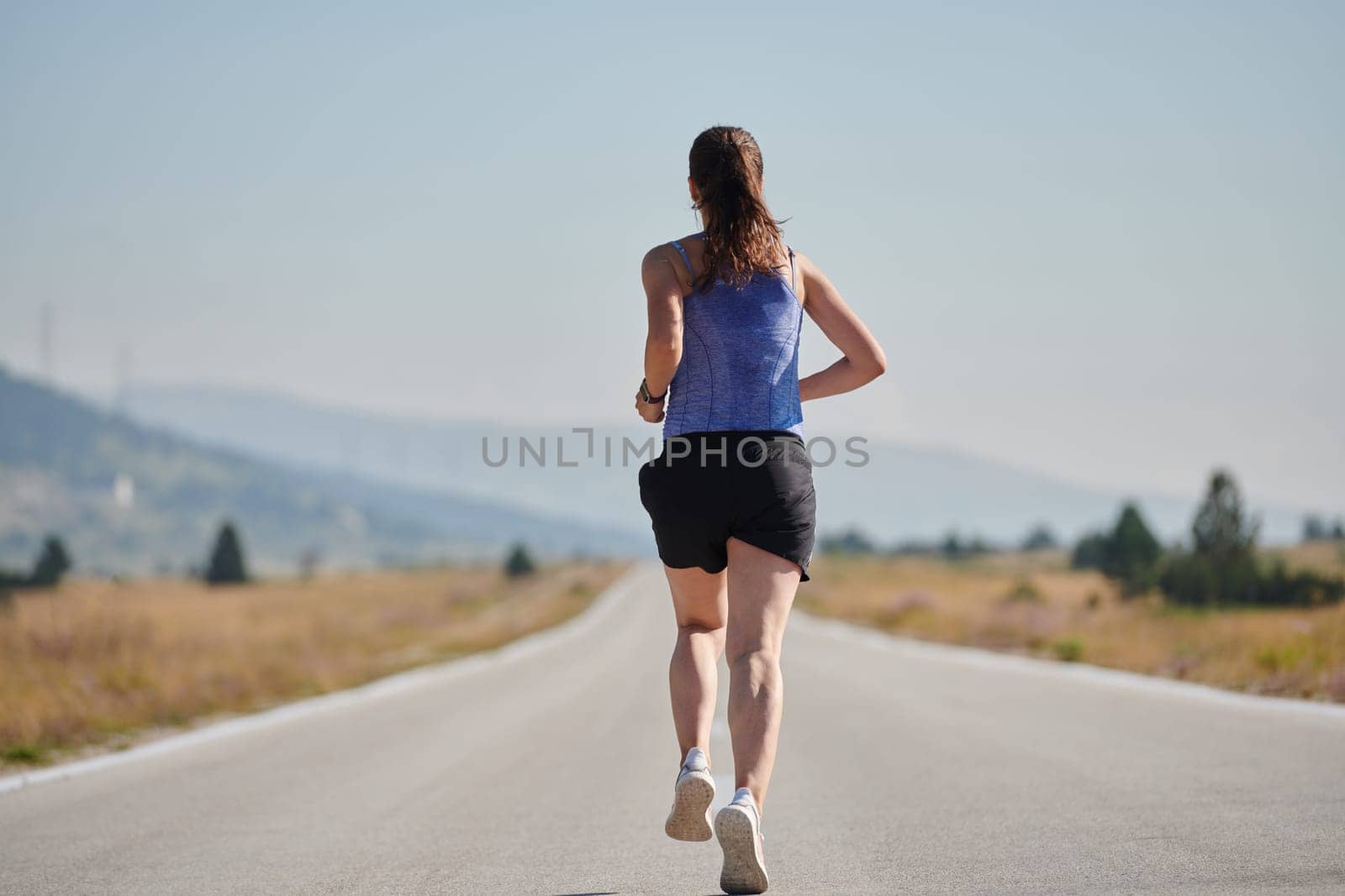 A determined woman athlete trains for success in the morning sun. by dotshock