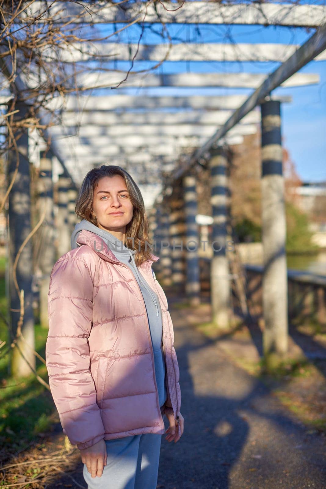 Winter Fun in Bitigheim-Bissingen: Beautiful Girl in Pink Jacket Amidst Half-Timbered Charm. a lovely girl in a pink winter jacket standing in the archway of the historic town of Bitigheim-Bissingen, Baden-Württemberg, Germany. by Andrii_Ko