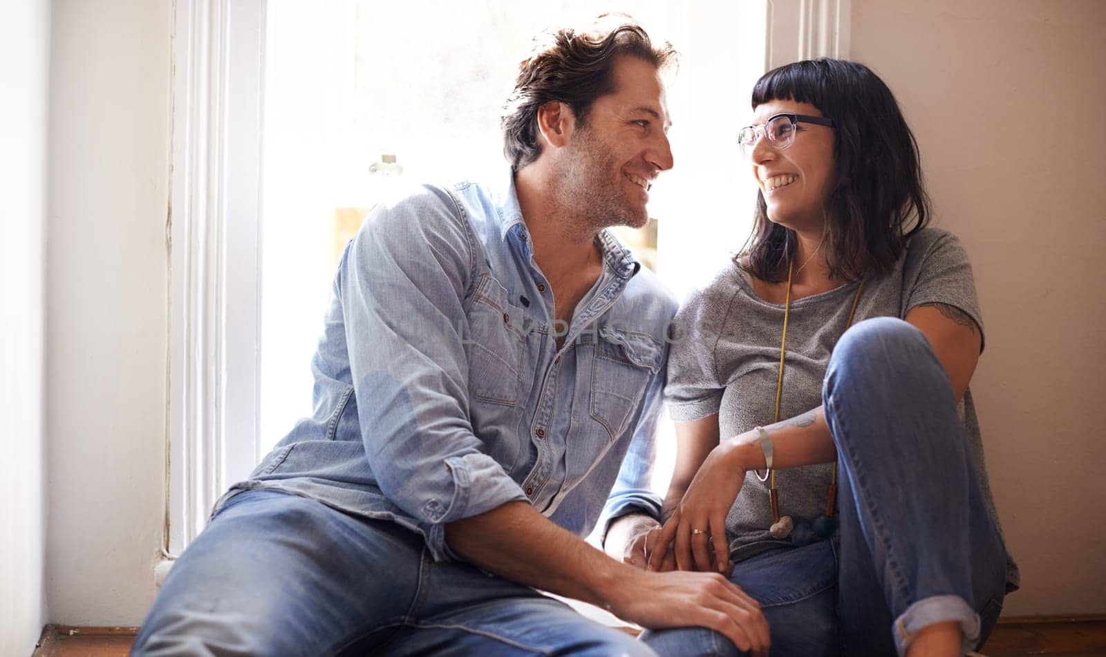 Floor, laughing or happy couple talking in home living room in conversation or speaking together. Man, funny woman or romantic people in apartment or house with love, support or joke humor to relax.