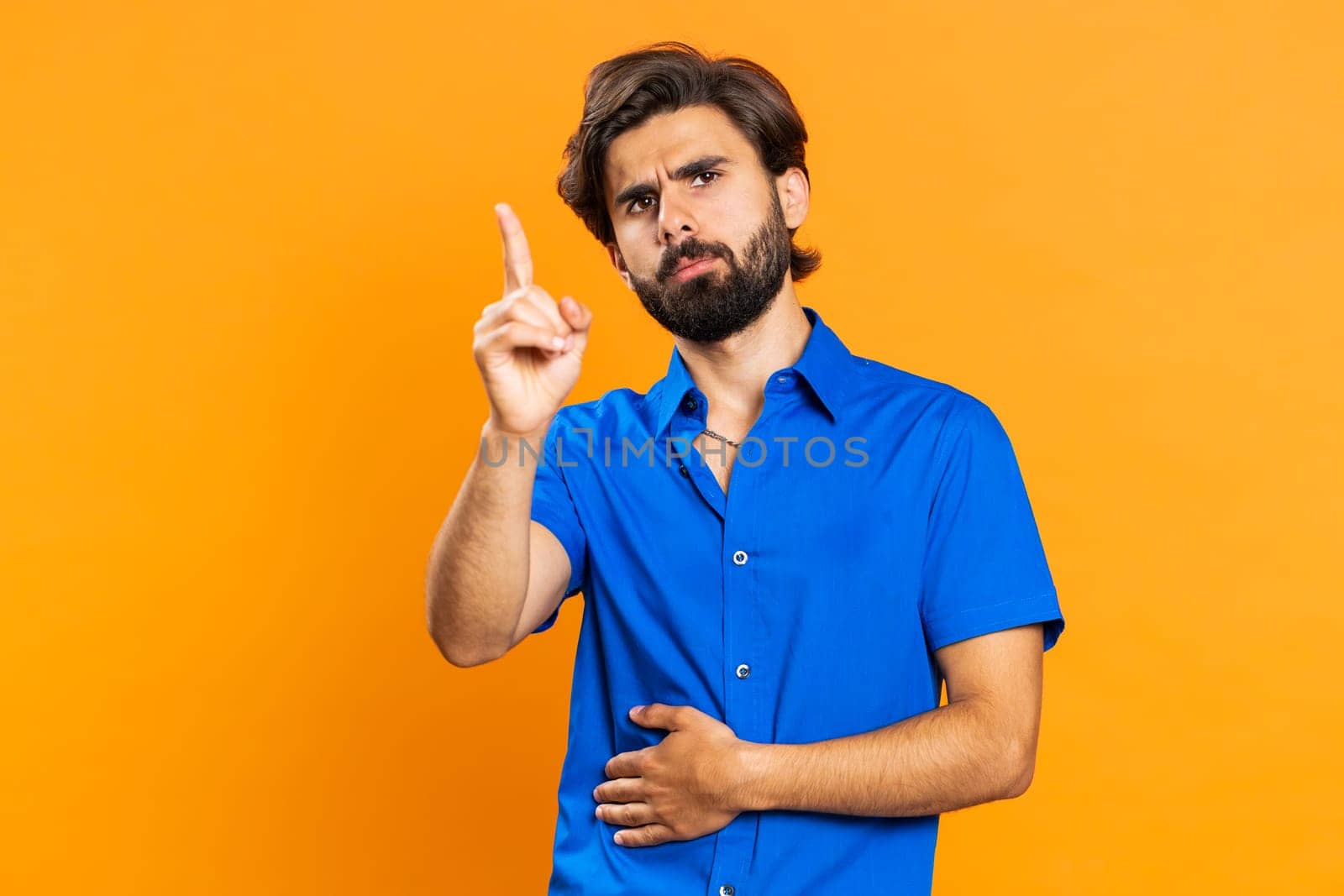 Displeased upset middle eastern man reacting to unpleasant awful idea, dissatisfied with bad quality, wave hand, shake head No dismiss idea dont like proposal. Guy isolated on orange studio background