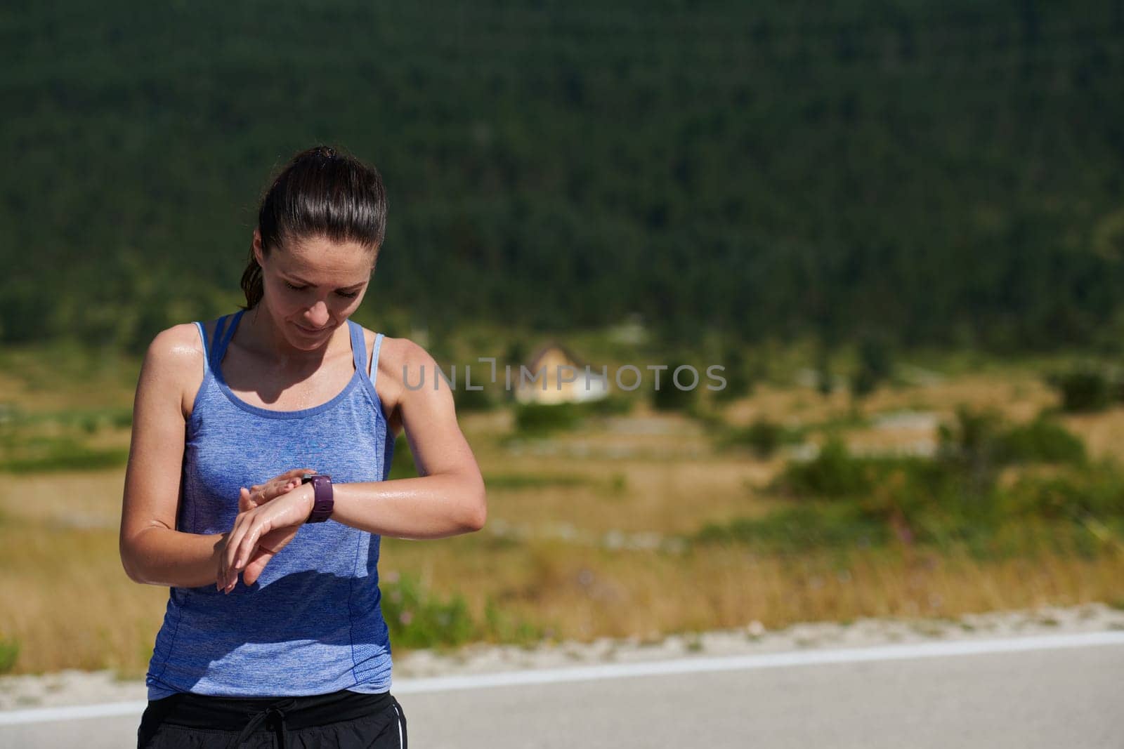 The athlete watches cardio, fitness in the city. A woman looks at sports and counts calories during training. Exercise coach on the street, healthy lifestyle.