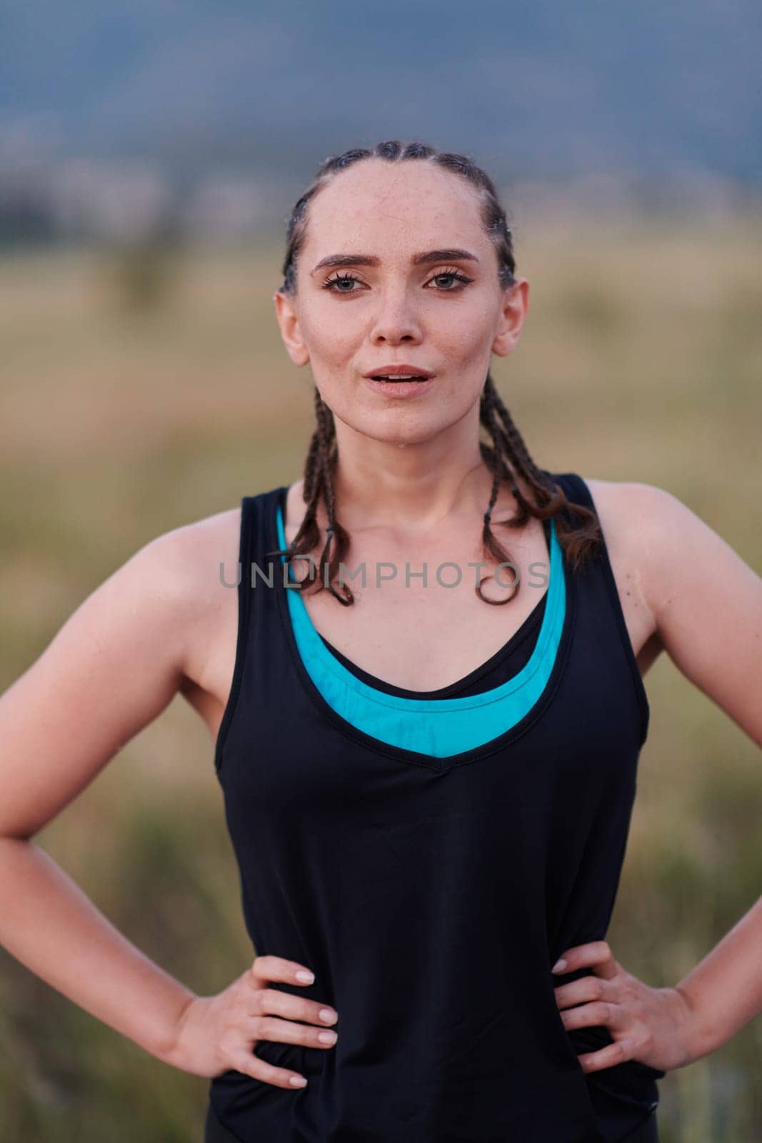 A close-up captures the raw dedication of a female athlete as she rests, sweat glistening, after a rigorous running session, embodying the true spirit of perseverance and commitment to her fitness journey