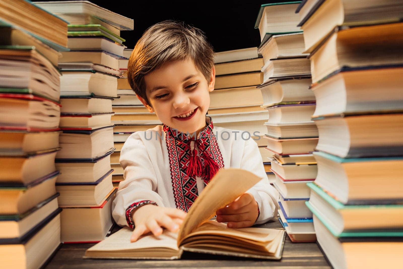 Handsome little ukrainian child flips through book pages in library. Elementary school boy enjoying reading in bookshop or bookstore. High quality 4k footage