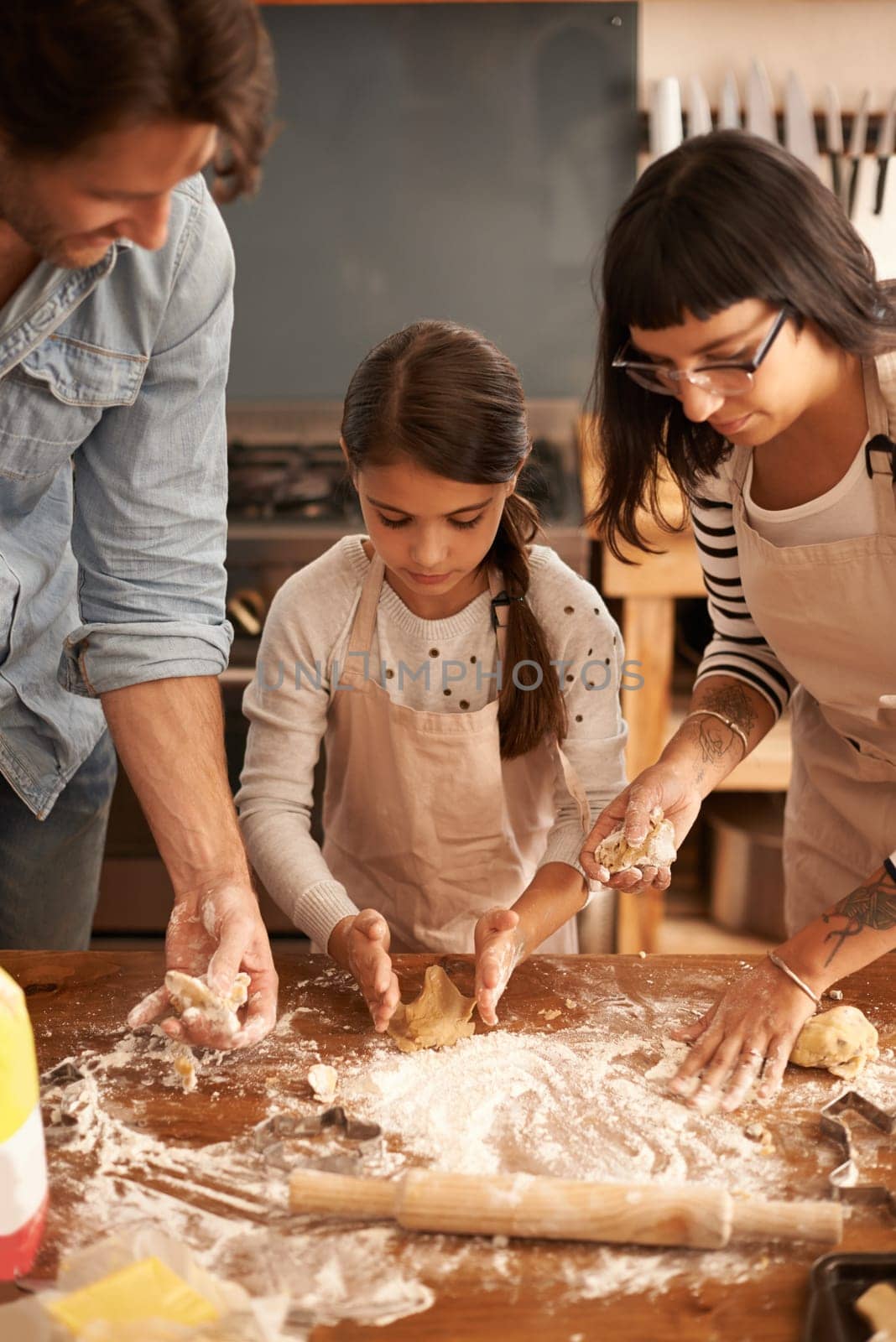 Mother, father and girl with flour for baking cookies in kitchen with dough, rolling pin and teaching with support. Family, parents and child with helping, learning and bonding with cooking for hobby.