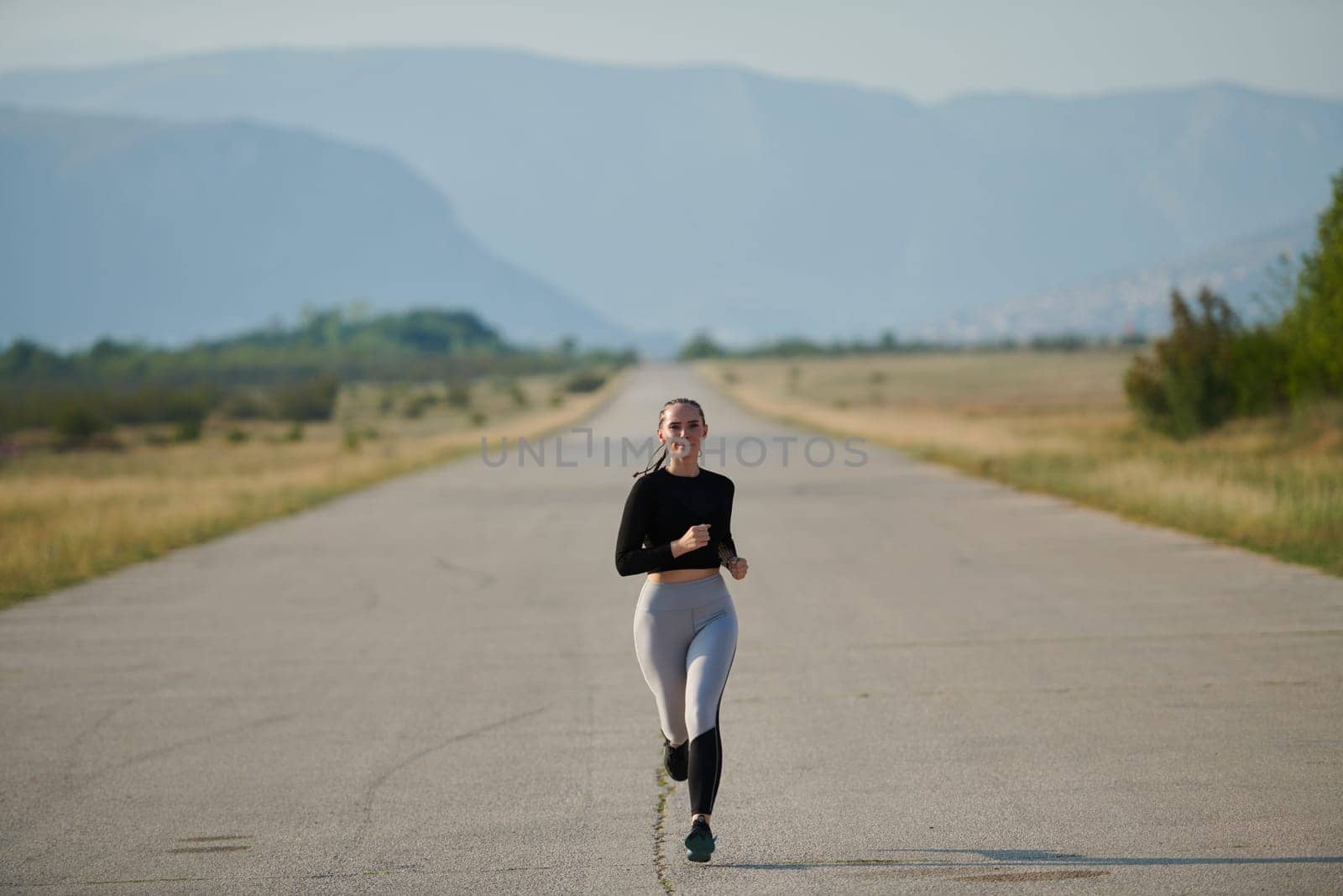 A determined woman athlete trains for success in the morning sun. by dotshock