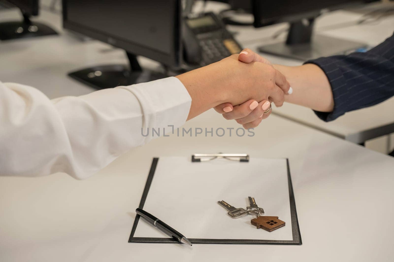 Real estate purchase transaction. Realtor and buyer shaking hands