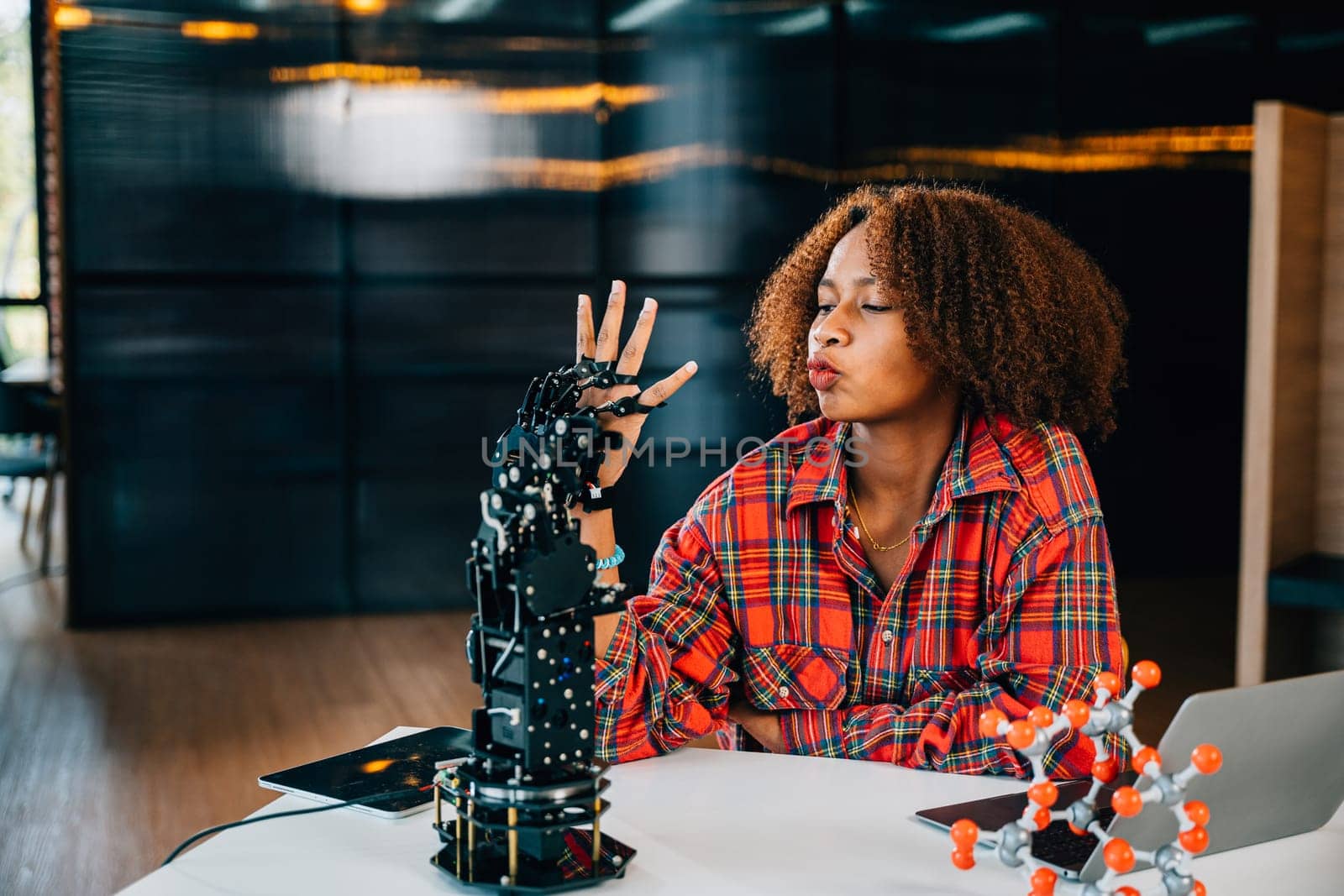 Smart teenager joyfully explores a humanoid robotic hand learning in a classroom setting. Embracing science and technology fostering innovation intelligence and skill development.