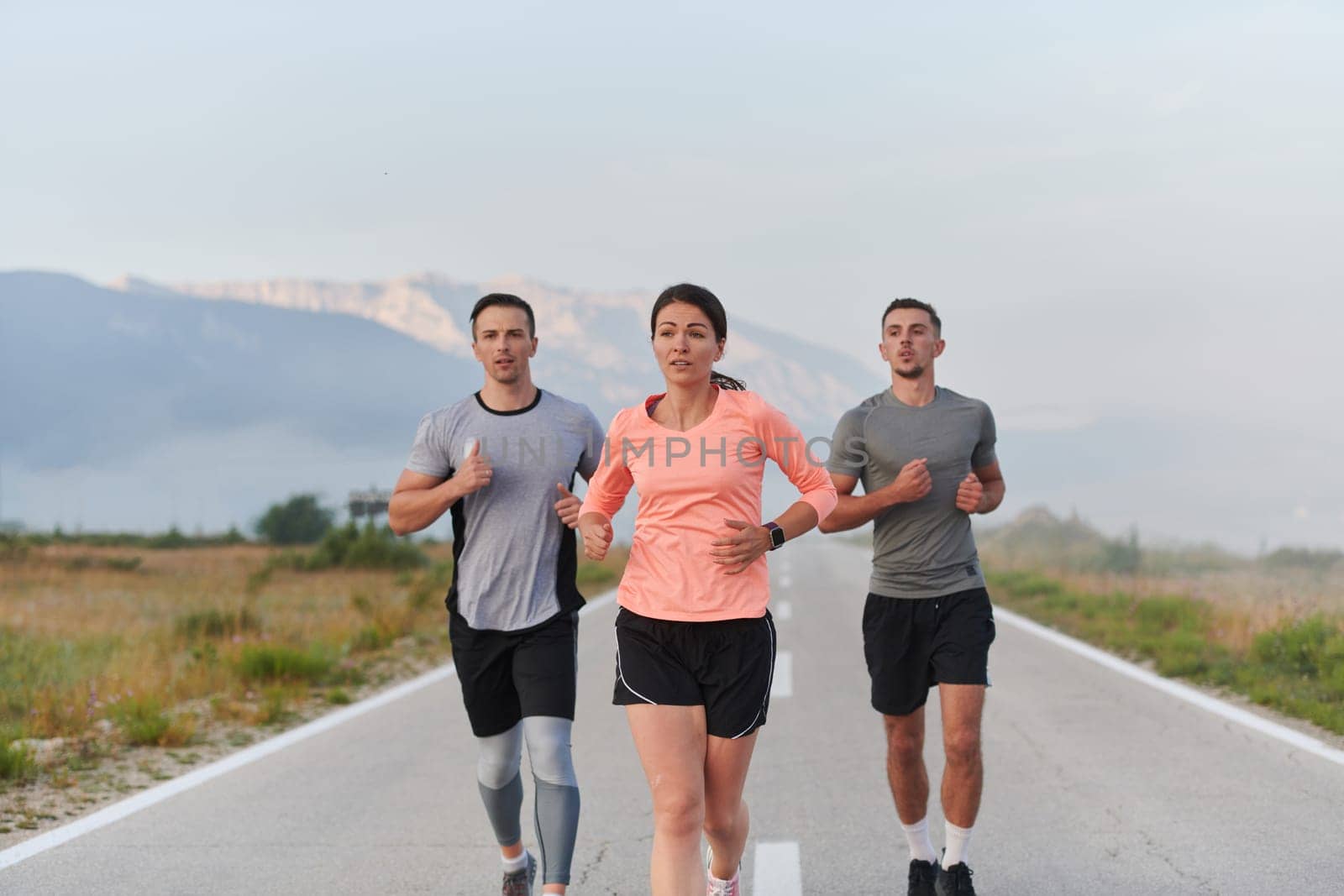 A group of friends, athletes, and joggers embrace the early morning hours as they run through the misty dawn, energized by the rising sun and surrounded by the tranquil beauty of nature by dotshock