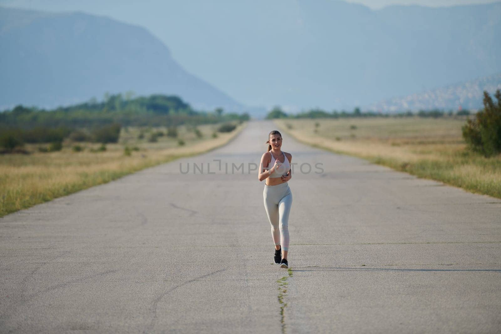 A determined woman athlete trains for success in the morning sun. by dotshock