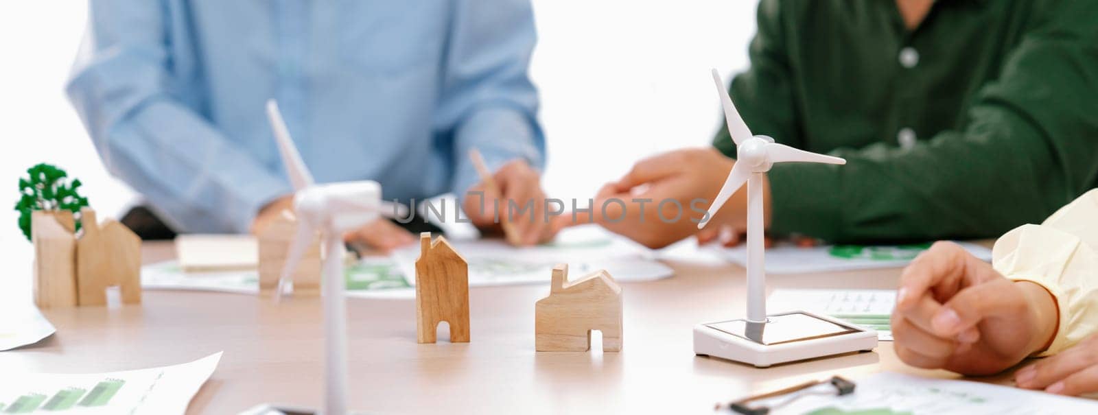 Green business meeting represented renewable energy. Skilled businesspeople discuss green business investment at table with environmental documents. Closeup. Focus on hand. Delineation.