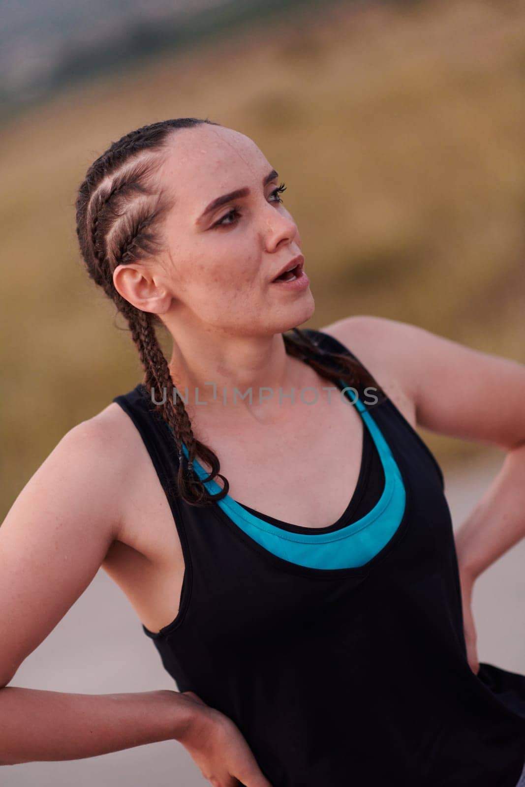 A close-up captures the raw dedication of a female athlete as she rests, sweat glistening, after a rigorous running session, embodying the true spirit of perseverance and commitment to her fitness journey