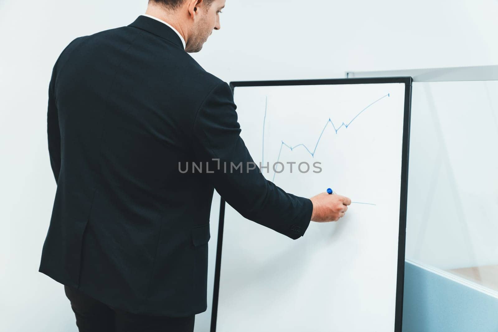 Smart male leader drawing increasing graph at business meeting room. Ornamented. by biancoblue