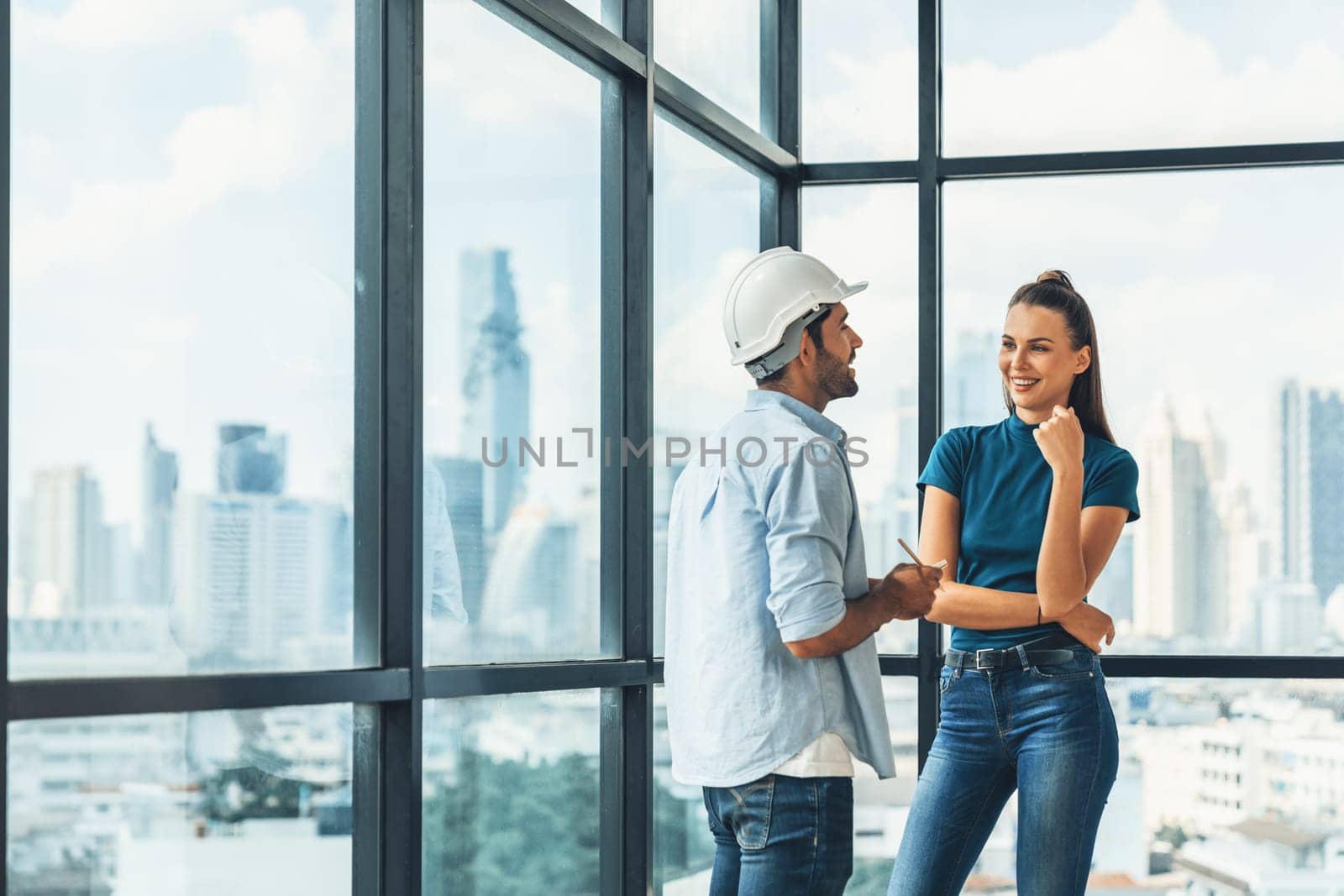 Professional smart architect engineer team discuss and solve building construction problems. Engineer taking a note while listening manager sharing idea about work surrounded by skyscraper. Tracery.