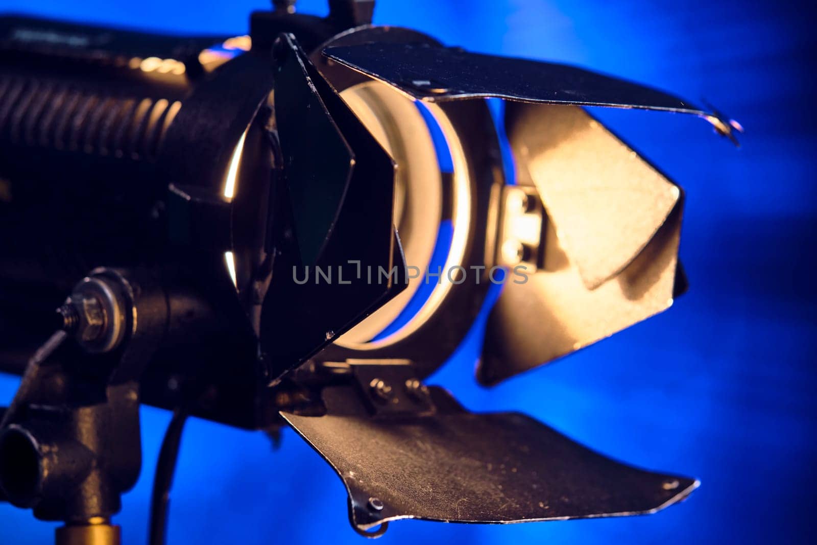 Close-up of a professional lighting fixture on a set or photographic studio. Concept of shooting a movie. color