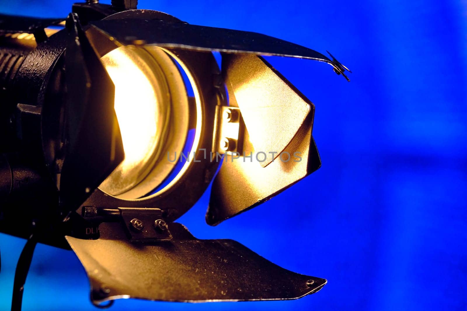 Close-up of a professional lighting fixture on a set or photographic studio. Concept of shooting a movie. by lempro