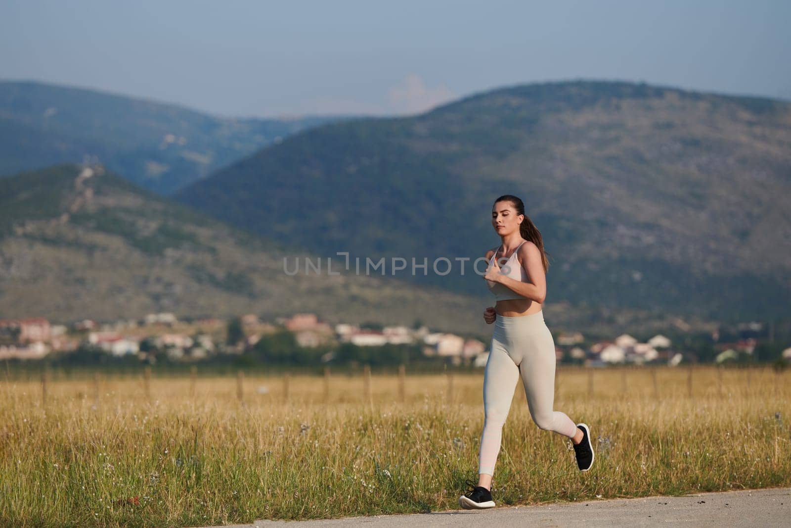 A determined woman athlete trains for success in the morning sun. by dotshock