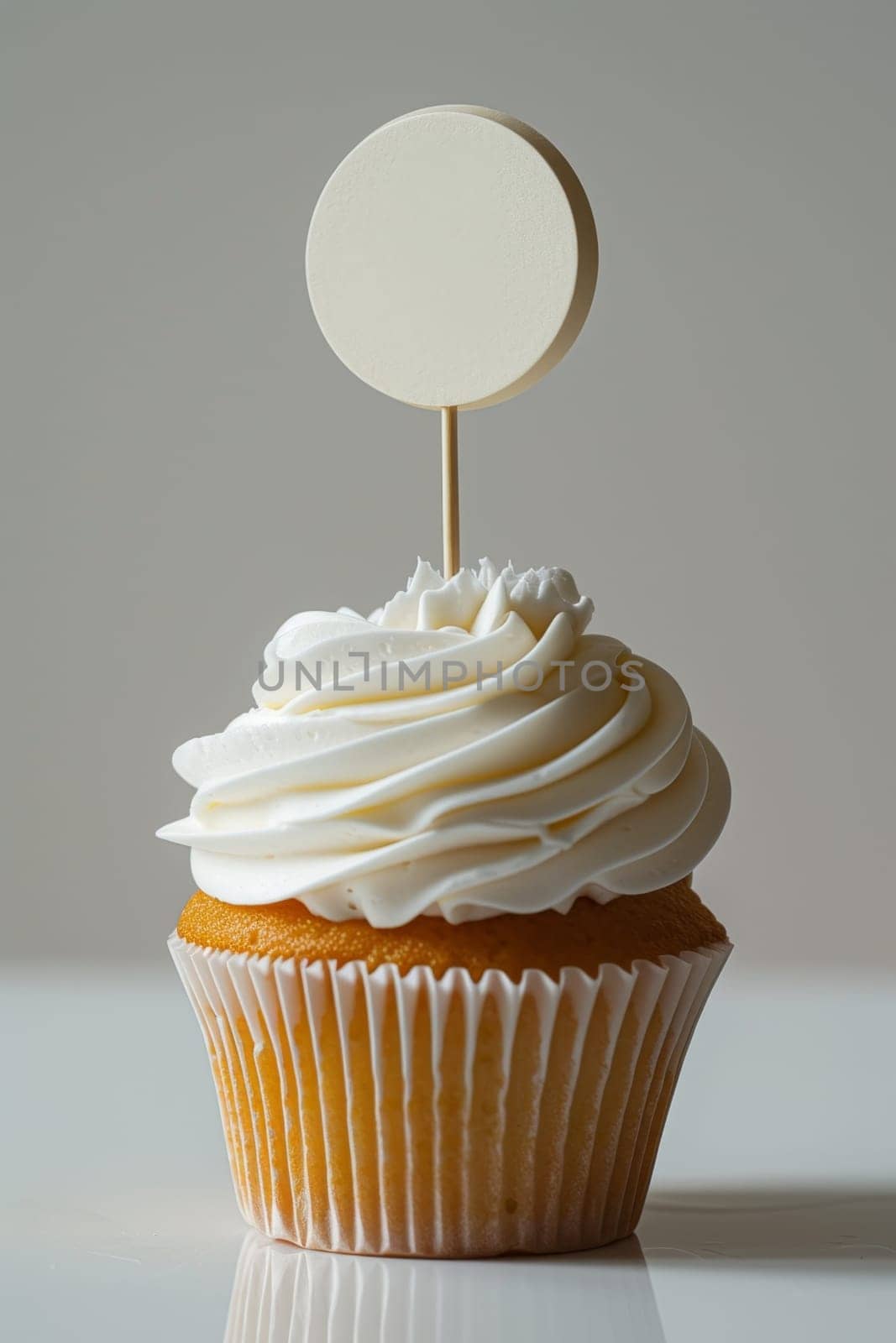 Cupcake with white cream and an inscription plate on a white background.