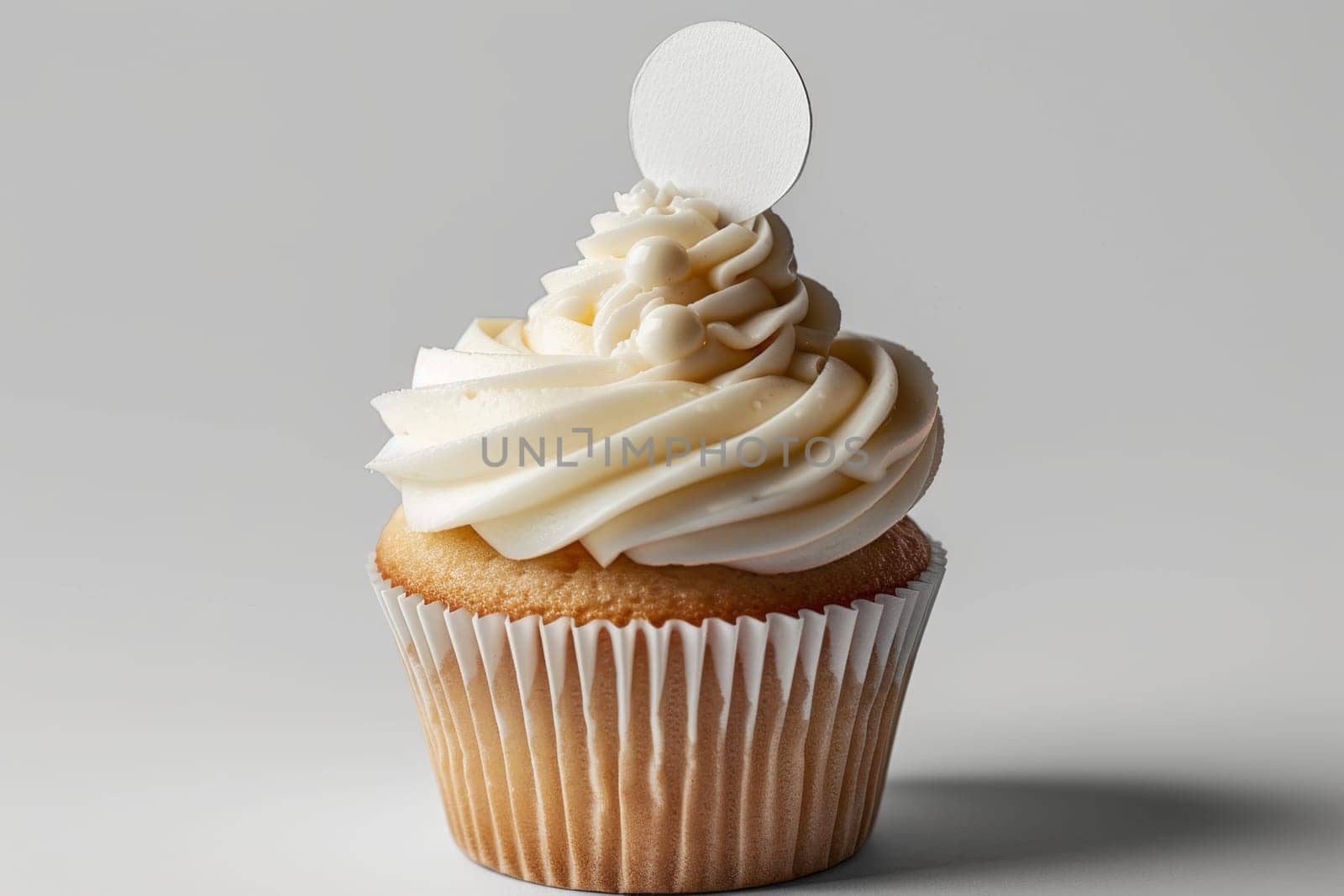 Cupcake with white cream and an inscription plate on a white background.