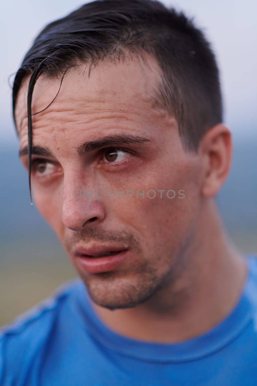 After completing a grueling daily run, a sweaty athlete takes a well-deserved rest, showcasing the physical exertion and dedication of their training regimen.