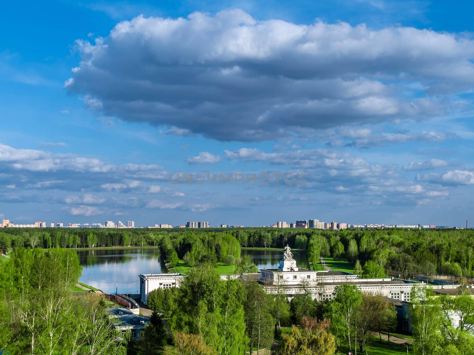 Beautiful view of the city park. Clouds on a sunny summer day