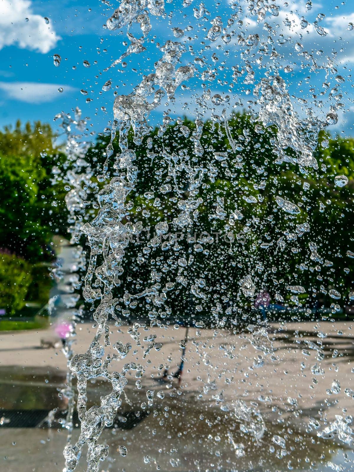 Fountain water jets working in a city park. day light by lempro