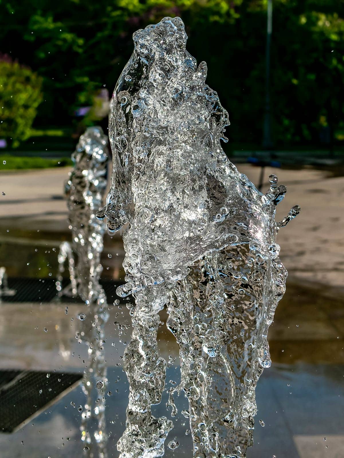 Fountain water jets working in a city park. day light by lempro