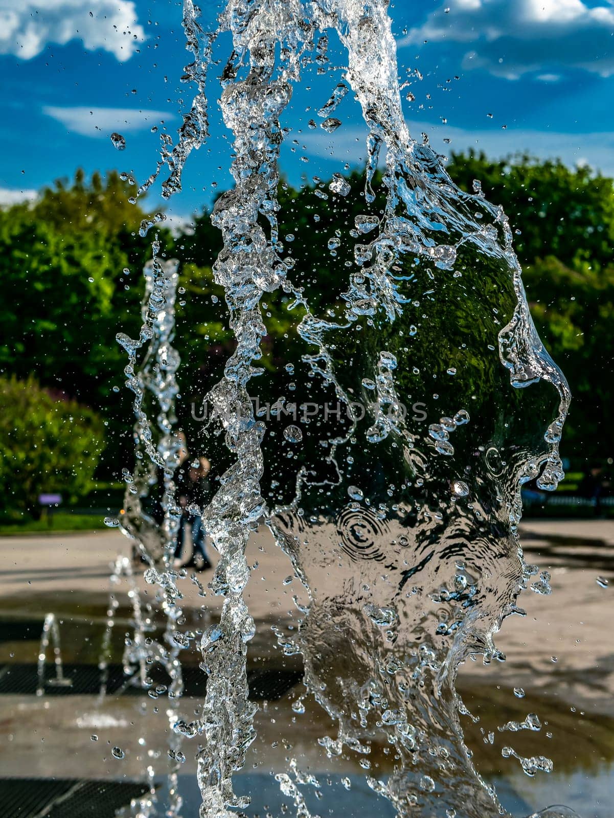 Fountain water jets working in a city park. day light by lempro