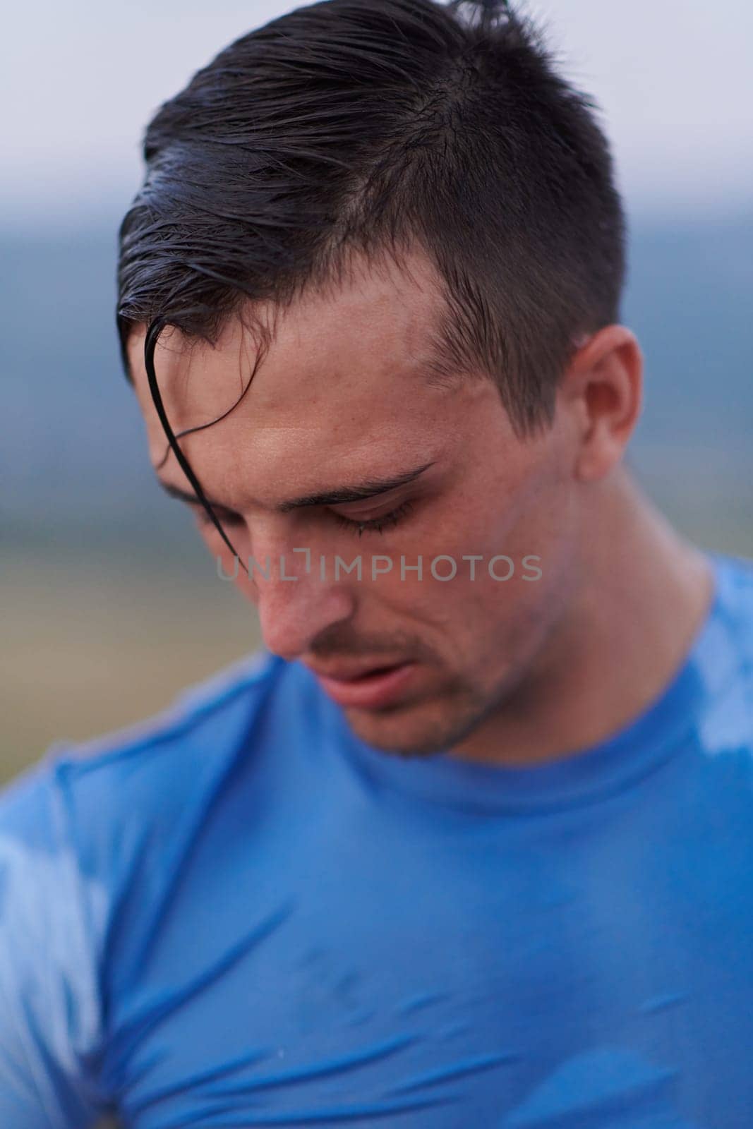 After completing a grueling daily run, a sweaty athlete takes a well-deserved rest, showcasing the physical exertion and dedication of their training regimen.