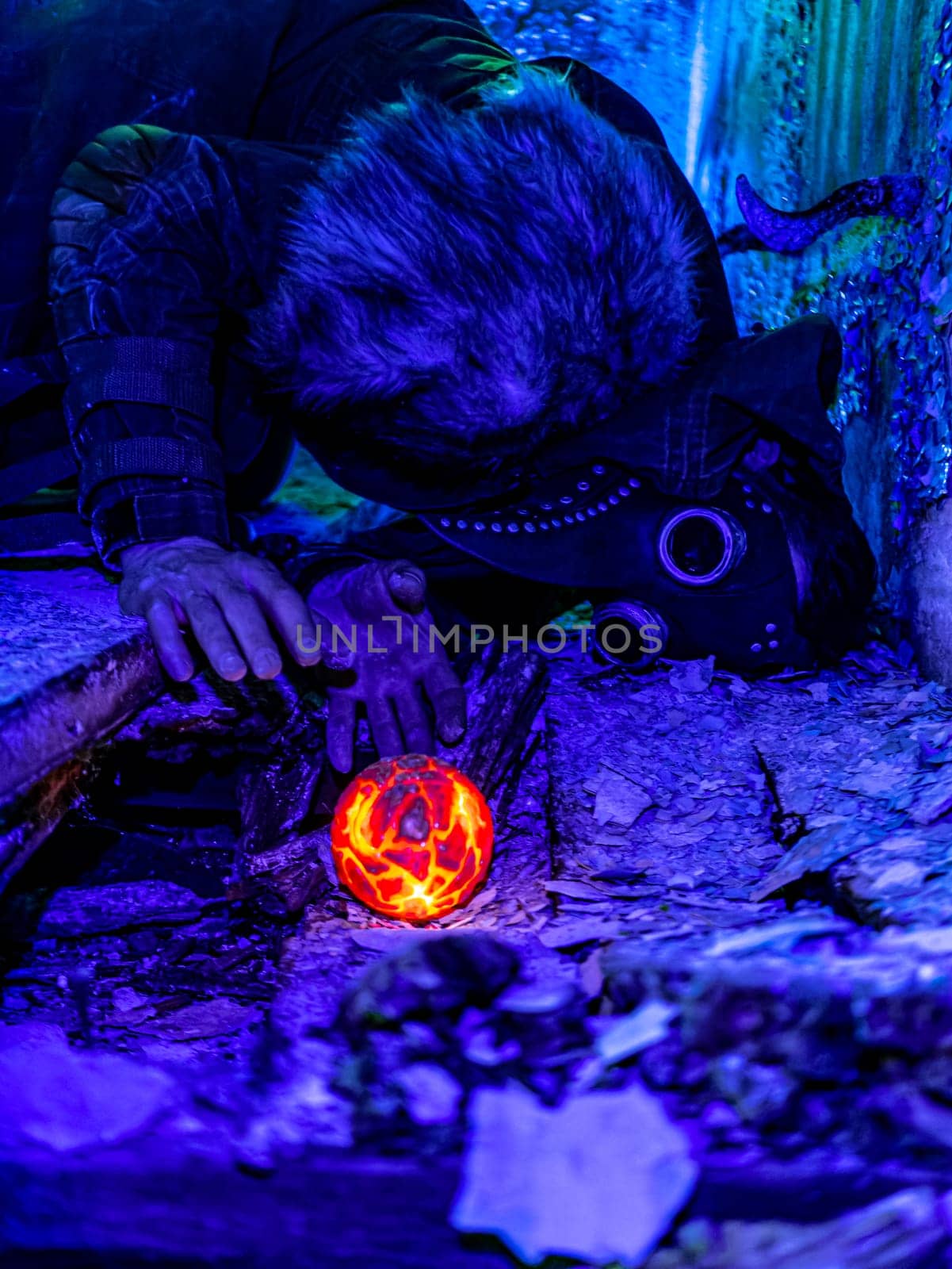 Cosplay of a stalker lying on the floor of an abandoned house in a plague doctor mask and holding a mysterious artifact. art photo