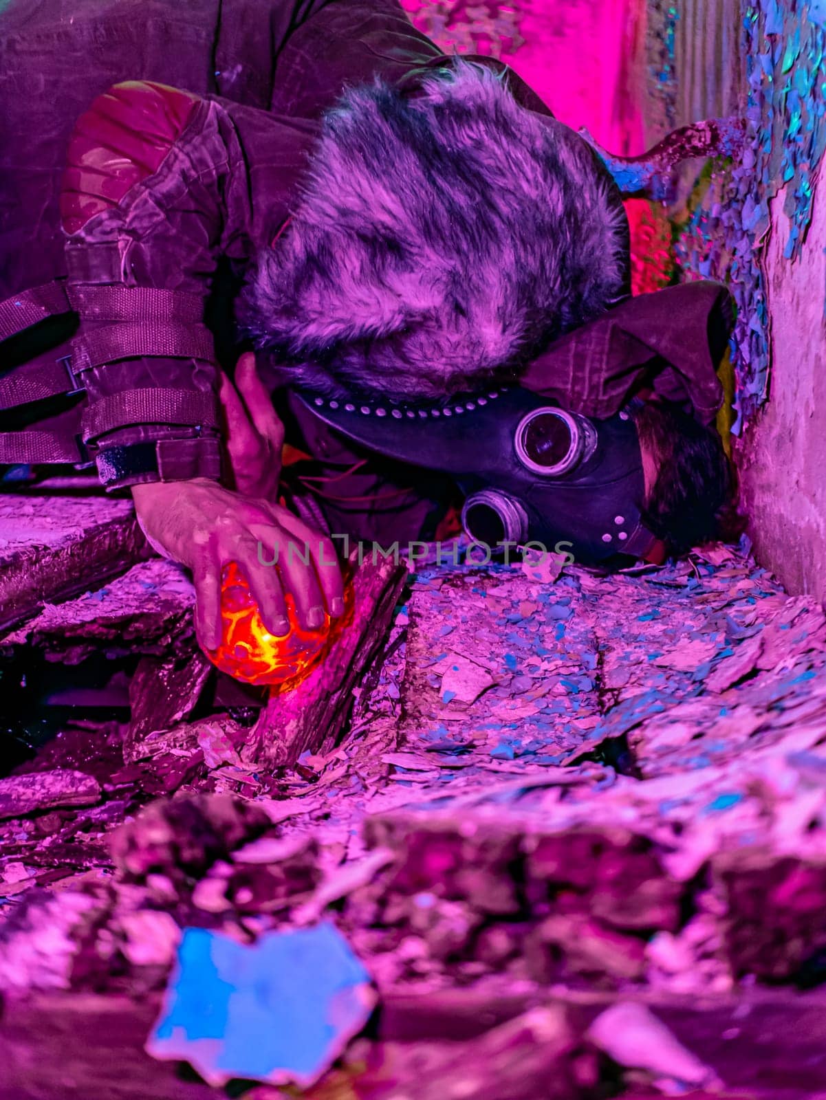 Cosplay of a stalker lying on the floor of an abandoned house in a plague doctor mask and holding a mysterious artifact. art photo