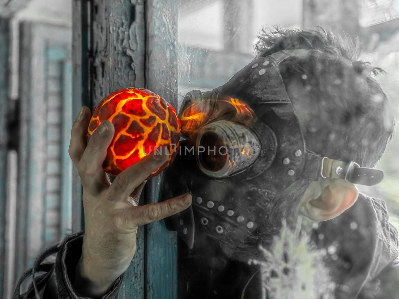 Cosplay of a stalker in a plague doctor mask holding a mysterious artifact and looking at it through glass