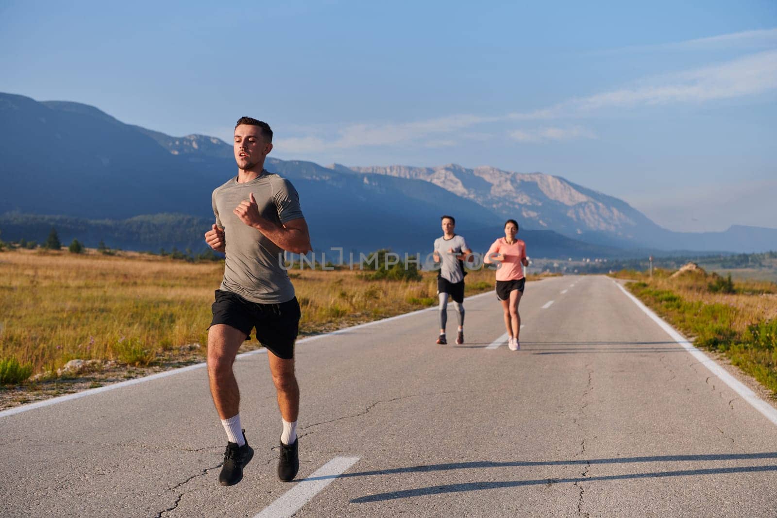 A group of friends maintains a healthy lifestyle by running outdoors on a sunny day, bonding over fitness and enjoying the energizing effects of exercise and nature by dotshock