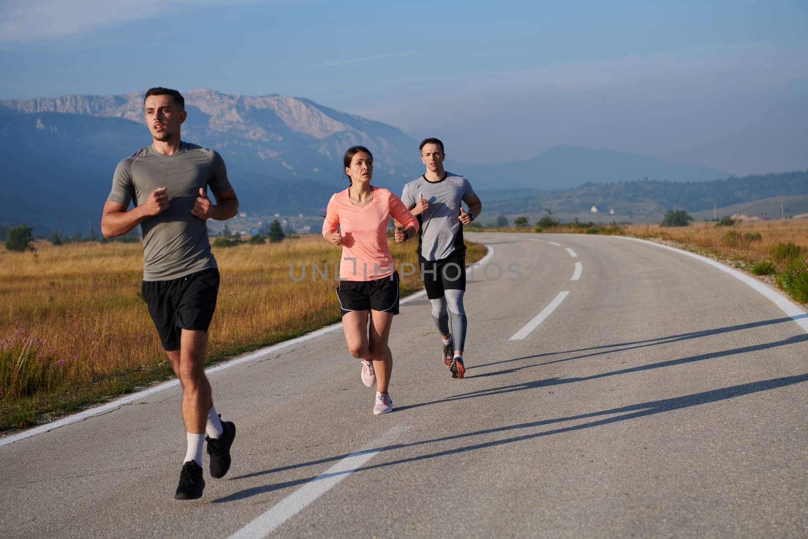 A group of friends maintains a healthy lifestyle by running outdoors on a sunny day, bonding over fitness and enjoying the energizing effects of exercise and nature by dotshock