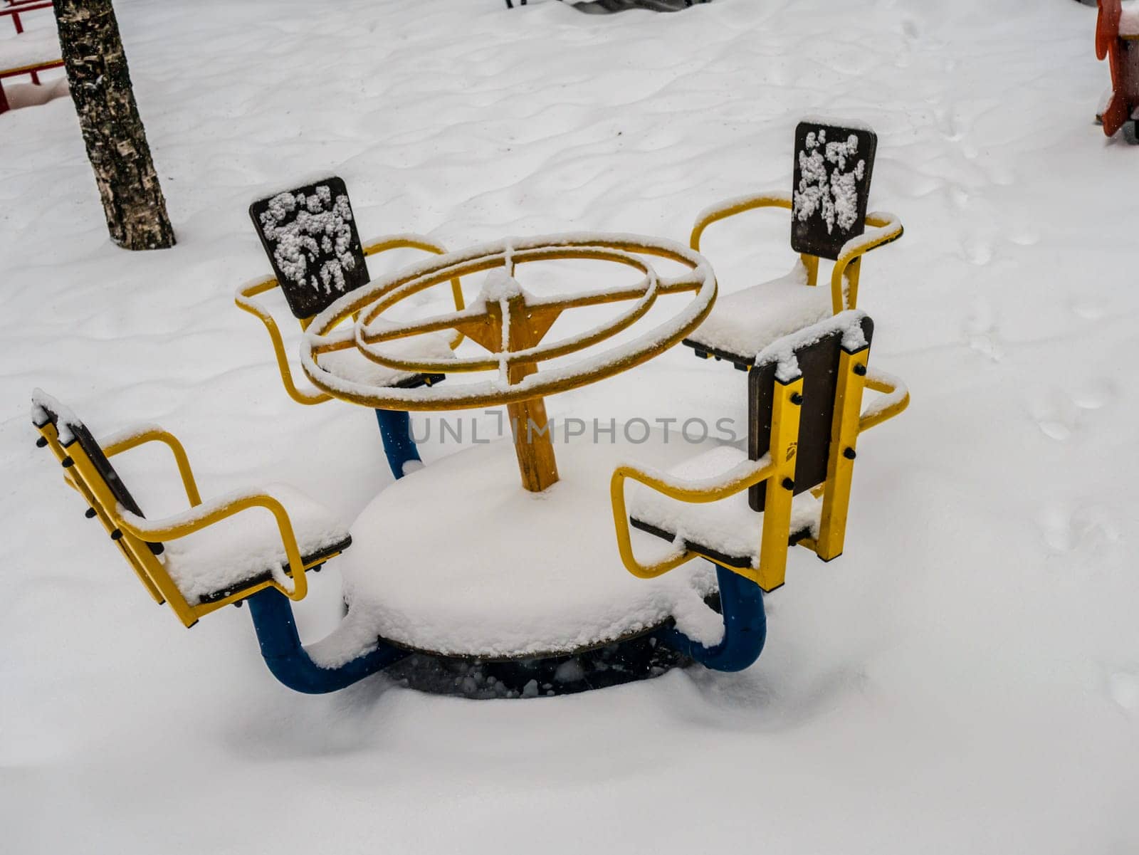 The playground in the courtyard of a residential building is buried under a large layer of snow, winter weather, snowfall by lempro