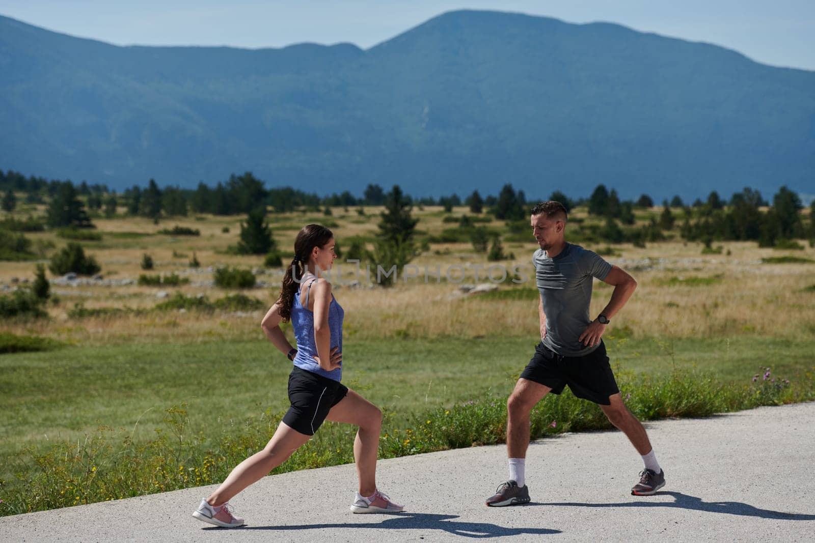 Exercise, mockup and couple workout and stretch together outdoors in nature by a mountain for health, wellness and fitness. People, partners and athletes training and keeping fit and heathy by dotshock