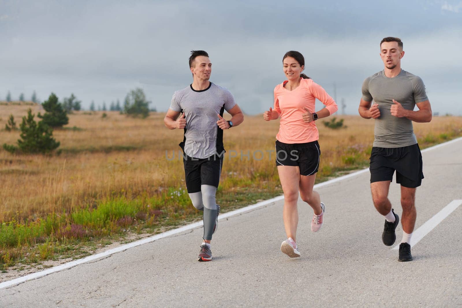 A group of friends, athletes, and joggers embrace the early morning hours as they run through the misty dawn, energized by the rising sun and surrounded by the tranquil beauty of nature by dotshock