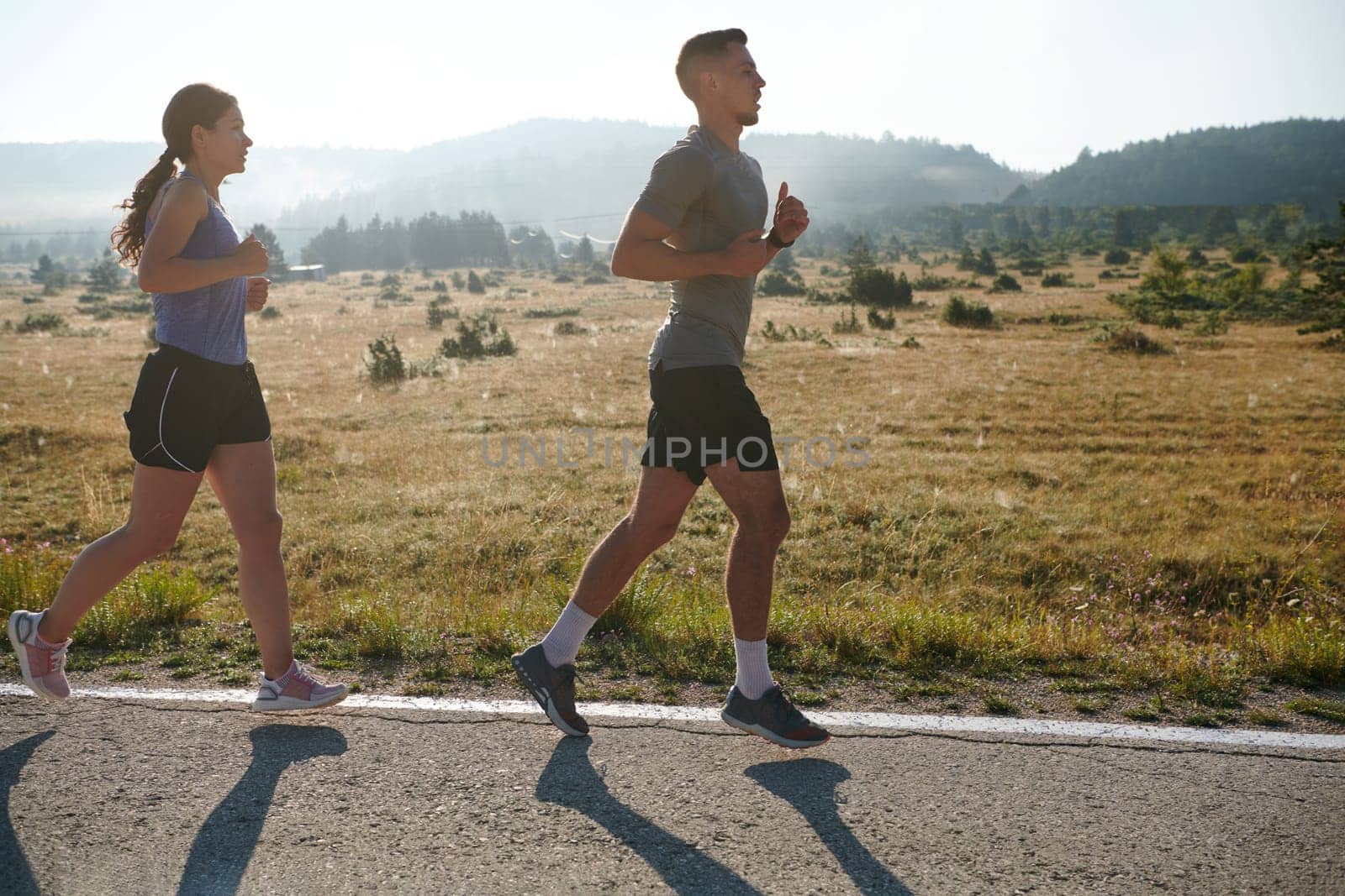Energized by the beauty of nature, a couple powers through their morning run, their bodies and spirits invigorated. by dotshock