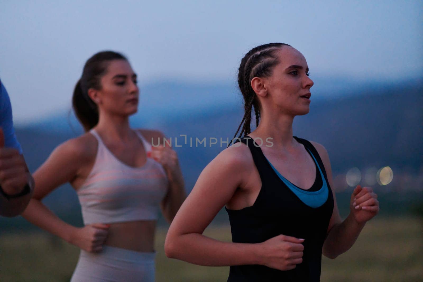 A diverse group of runners trains together at sunset. by dotshock