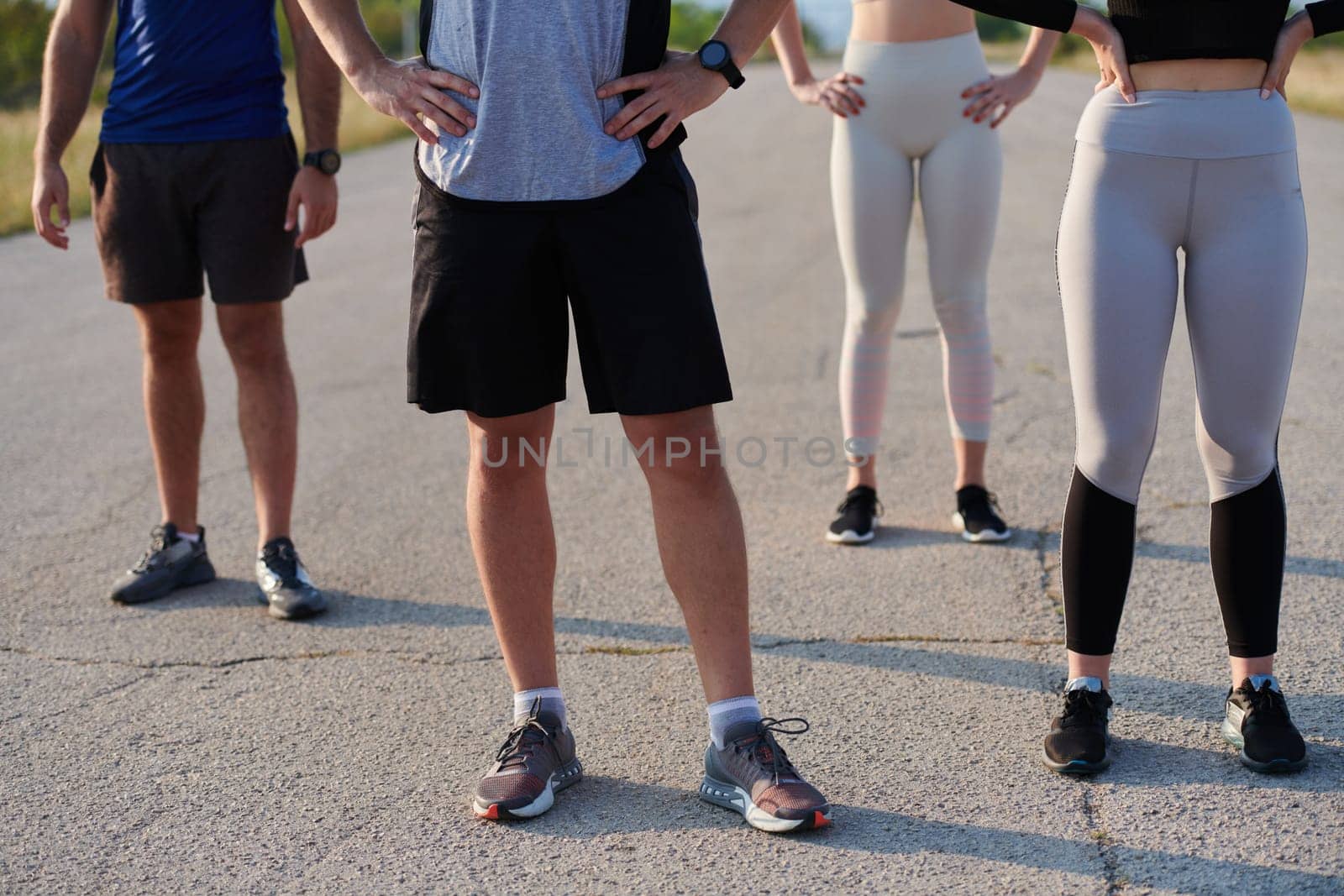 Diverse Athletic Warm-Up: Group Prepares for Intense Running Challenge. by dotshock