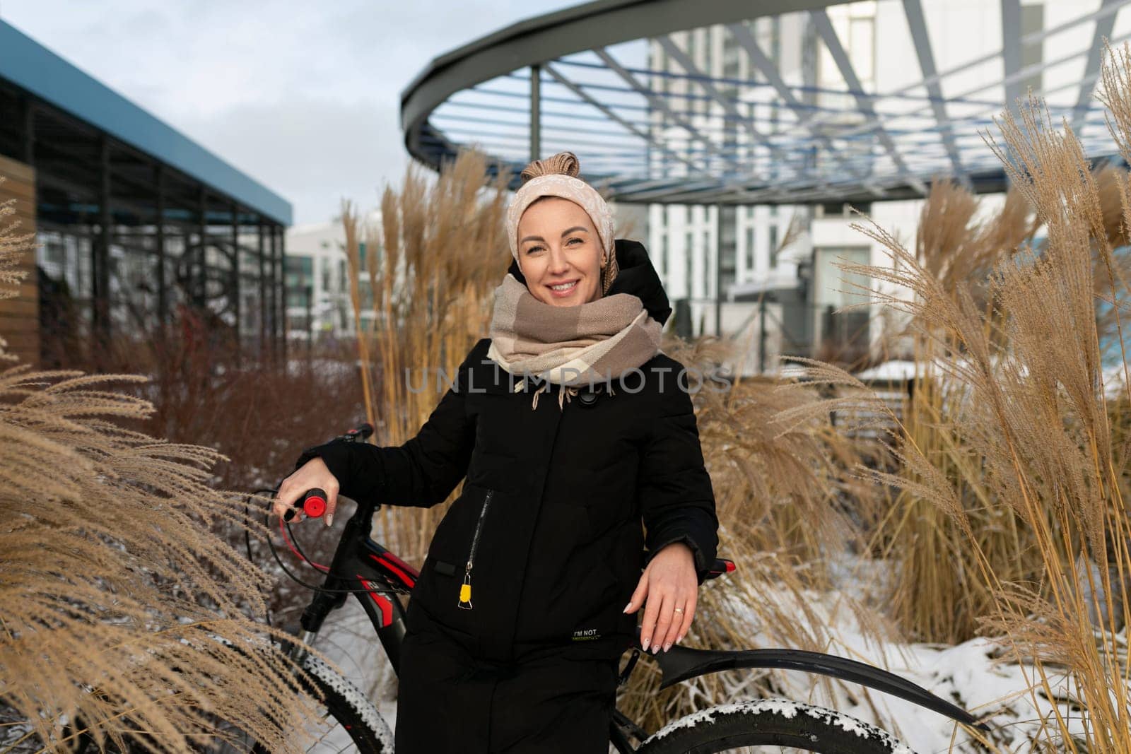 Athletic active young woman riding a bicycle on the street in winter.