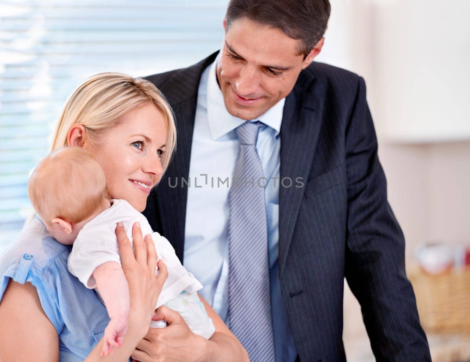 Home, businessman and mother smile with baby in morning as family, couple and parents together. House, man and woman with child in kitchen with happiness for growth and development of infant.