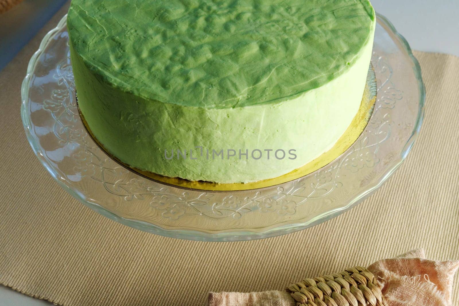 Green cake takes center stage on a glass plate, showcasing its vibrant hue and delicate elegance. by darksoul72