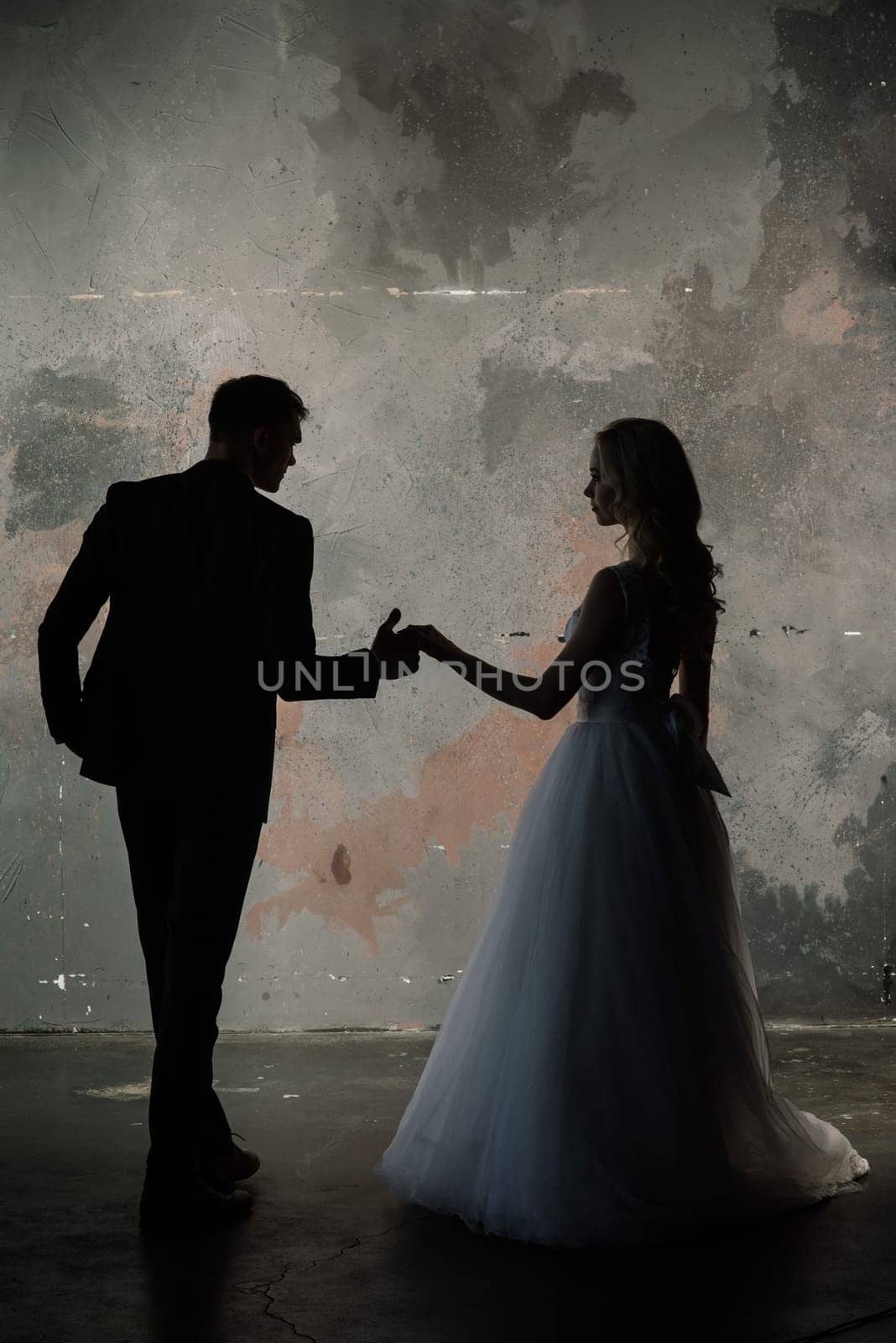 Art fashion studio photo of wedding couple silhouette groom and bride on colors background.